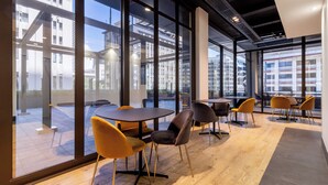 Een modern interieur met grote ramen, houten vloeren en eigentijds meubilair.