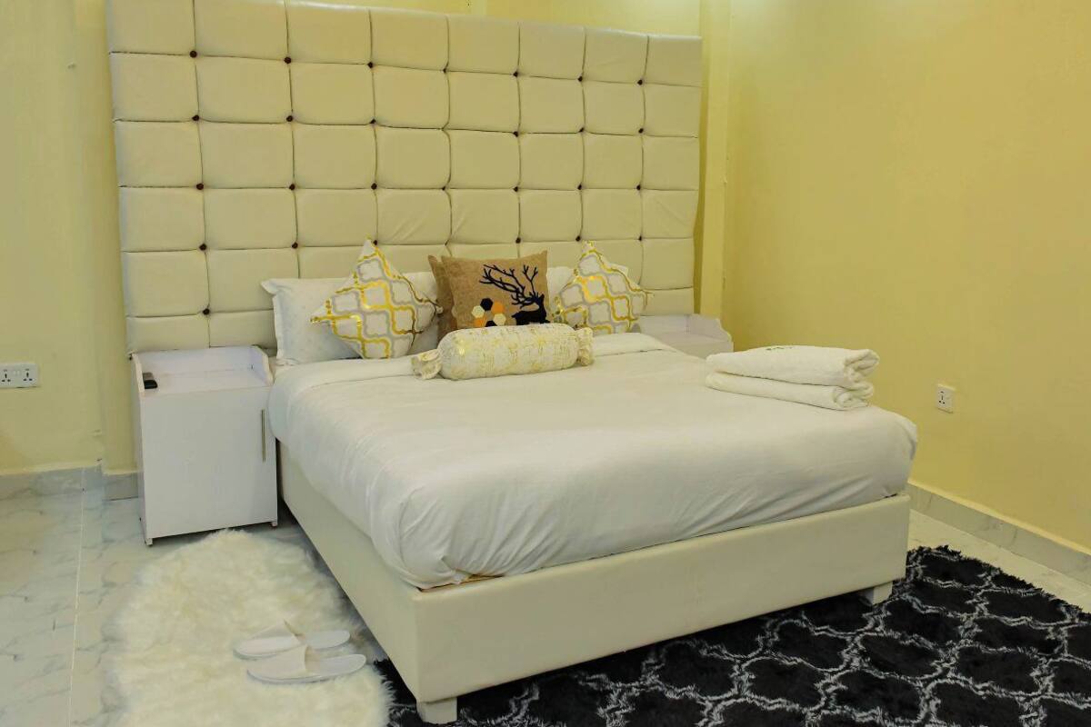 A bedroom with a large bed, a nightstand, and a headboard.