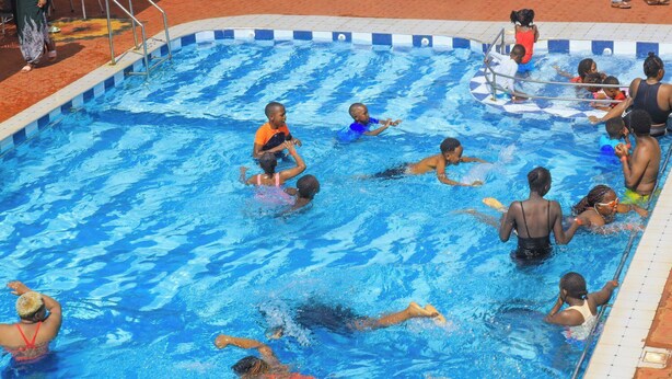 A swimming pool with multiple lanes and swimmers.