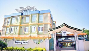 A multi-story hotel with a prominent entrance and a sign reading "Stepwing Resort." - Stepwing Resort (Nyeri)