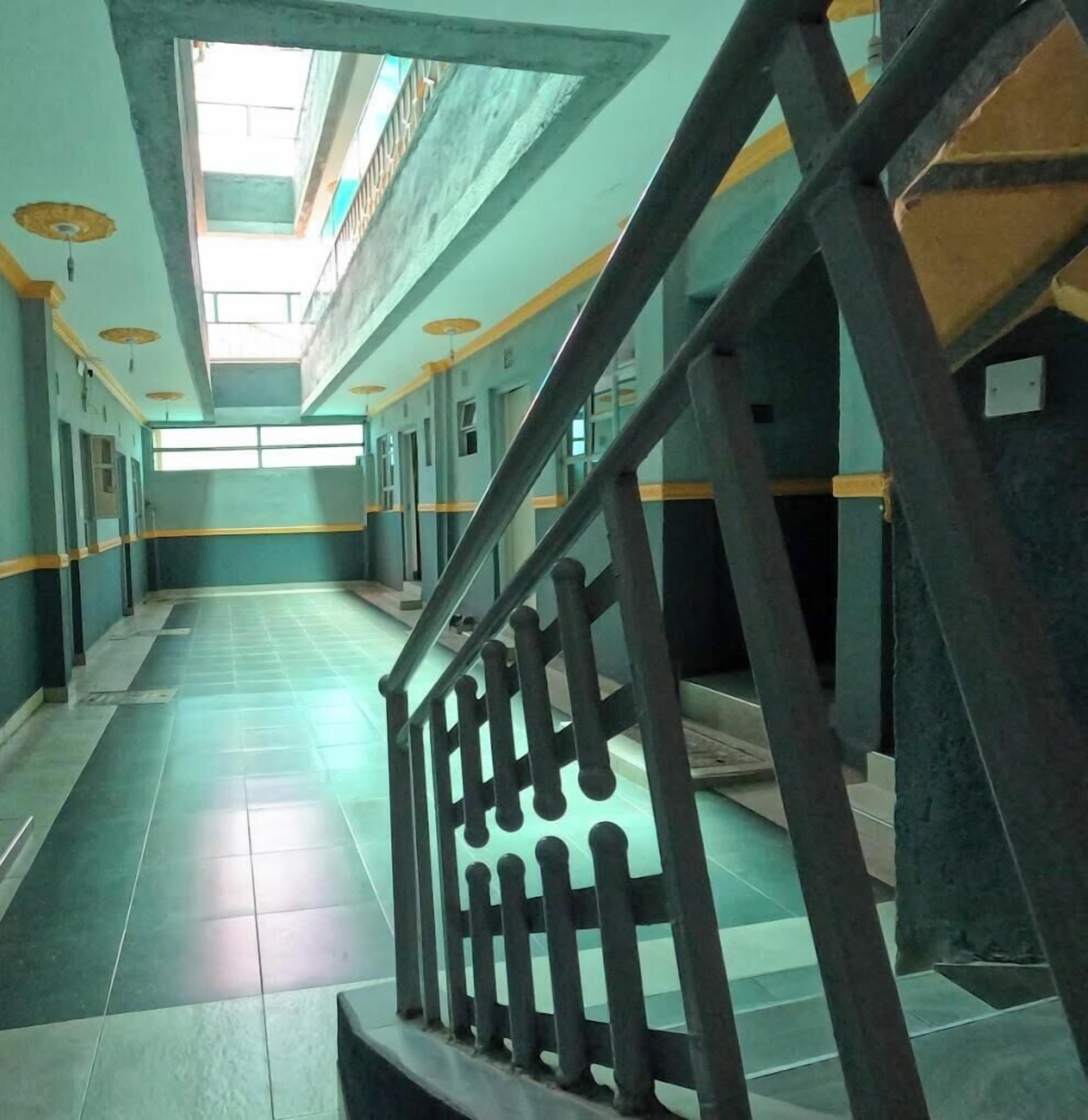 A long corridor with a staircase on the right, leading to an upper level.