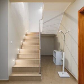 A staircase with a handrail, a white wall, and a wooden door. - The Charm of Ponta Delgada (Ponta Delgada)