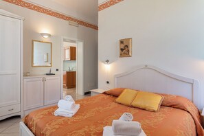 A hotel room with a bed, a wardrobe, a bathroom, and a hallway.