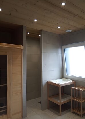 Une pièce avec une armoire en bois, une petite table et une fenêtre.
