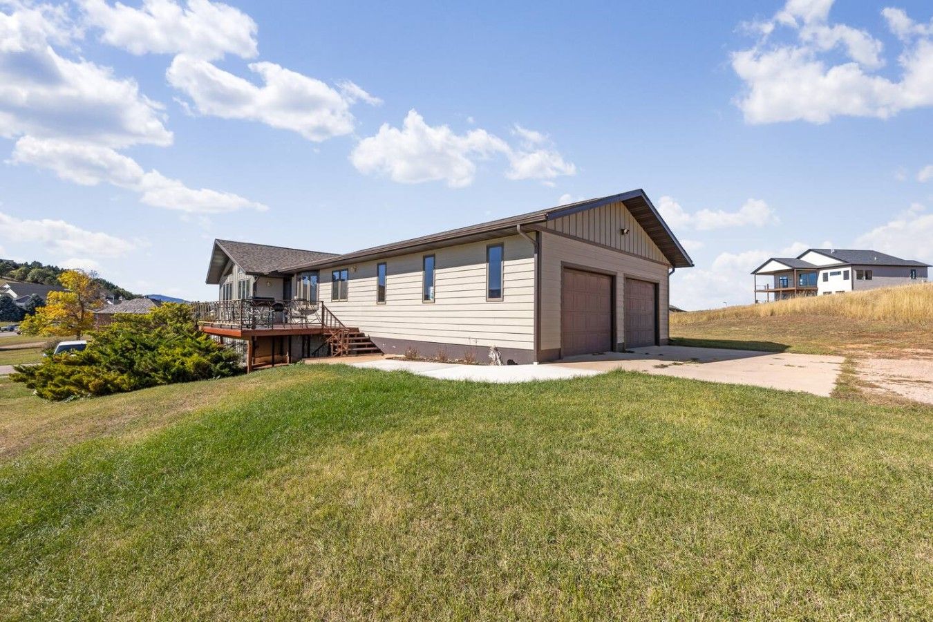 A two-story house with a front deck and a garage.