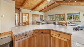 A spacious kitchen with wooden cabinets, a large island, and a ceiling fan.