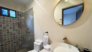 A bathroom with a shower, toilet, sink, and a large mirror. - Esencia Valladolid Hotel (Valladolid)