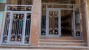 A building entrance with a metal gate and a balcony. - First site of pyramids view hotel (Giza Governorate)