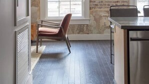 A kitchen with a brick wall, a window, and a chair. - The Gregory Suite 202 (New Orleans)