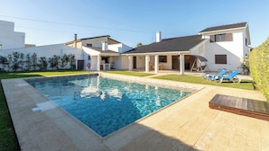 A modern house with a swimming pool, a covered patio, and a lawn. - Ma-la Beach House by HostWise (Marinhas)
