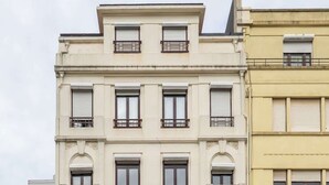 A multi-story building with a ground-floor shop named "ISTANBUL FASHION" and a red car parked in front. - Modern & Cozy Flat with Workspace by HostWise (Porto)