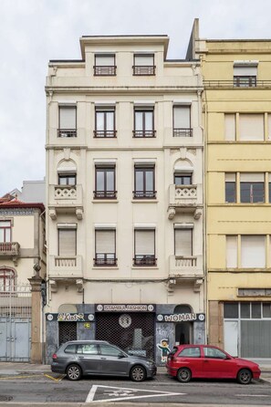 Ein mehrstöckiges Gebäude mit Eingangsbereich im Erdgeschoss, erkennbar an einem Schild mit der Aufschrift 'ISTANBUL FASHION WOMAN'.