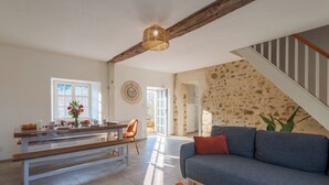 A spacious living area with a sofa, a round coffee table, and a dining table with chairs.
