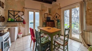 A rustic kitchen with a wooden table and chairs, a small refrigerator, and a sink. - House & Lake - Pescate - Lecco (Galbiate)
