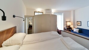 A hotel room with a bed, a desk, a chair, a sofa, and a wardrobe. - Monforte 19 - Milano (Milan)