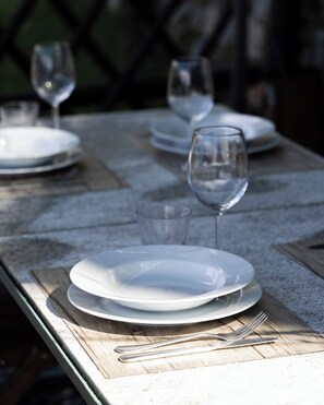 Una mesa de comedor con platos, vasos y cubiertos.