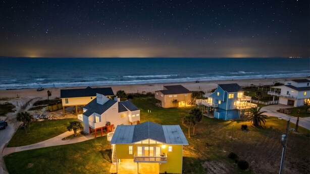 A residential area with houses, a beach, and a clear night sky. - Coastal/Cozy- Steps to the sand and sea (Jamaica Beach)