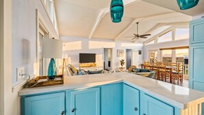 A spacious kitchen with blue cabinets, a large island, and pendant lights. - Coastal/Cozy- Steps to the sand and sea (Jamaica Beach)