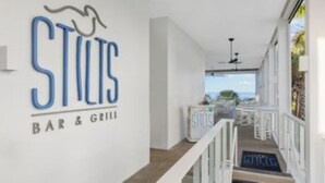 Un escalier menant à un bar-restaurant avec vue sur l’extérieur.