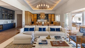 A spacious living area with a large sofa, a coffee table, and a chandelier.