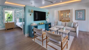 A modern living room with a TV, sofa, chairs, and a dining area.