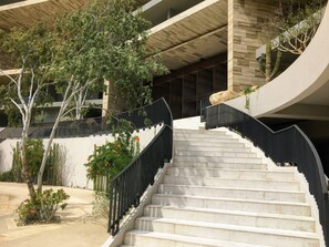 Una escalera con barandilla negra que lleva a la entrada de un edificio.