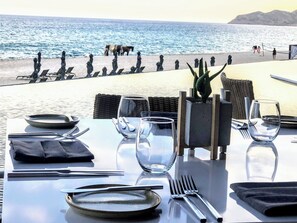 A table set for two with a view of the beach and horses in the background. - The Club at Solaz is a Luxury Villa with a beautiful view of the Sea of Cortez. (San José del Cabo)