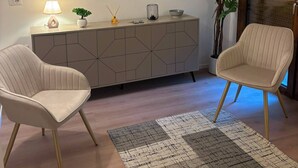A modern living room with two chairs, a sideboard, a lamp, and a potted plant. - Urban Stay Siena (Siena)