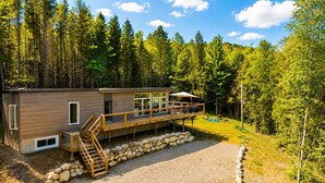Une cabane dotée d’une terrasse, d’un escalier et d’un mur en pierre.