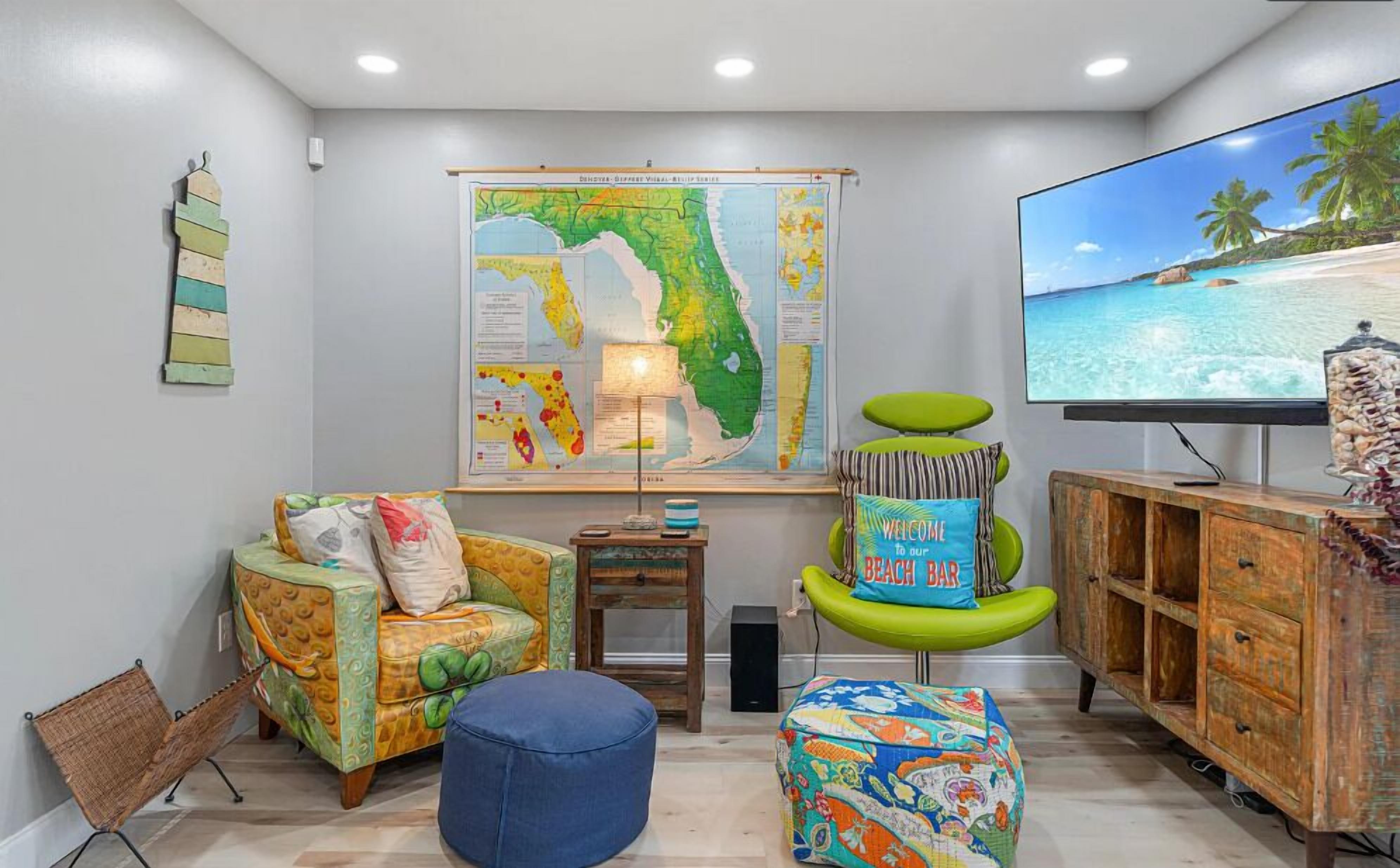 Ein Wohnzimmer mit einer großen Karte von Florida, einem Fernseher, der eine Strandansicht zeigt, und einer Holzkabine.