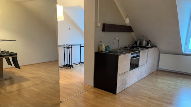 Een moderne keuken met een centraal eiland, een ingebouwde oven en een raam voor natuurlijk licht.