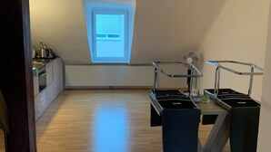 Een moderne keuken met dakraam, ventilator en een klein keukenhoekje.
