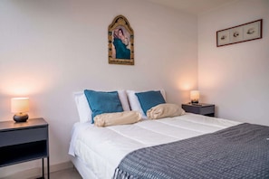 Ein Hotelzimmer mit einem Bett, zwei Nachttischen und einem Wandbild.