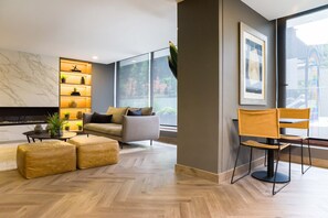 Marble-look TV wall in common area, illuminated display shelving, comfortable sofa seating, and floor-to-ceiling windows. - Beautiful Apartment in Nunoa with Balcony and Pool (Ñuñoa)