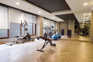 A gym with exercise equipment, large windows, and a herringbone floor pattern. - Beautiful Apartment in Nunoa with Balcony and Pool (Ñuñoa)