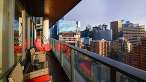 Un balcone con mobili in vimini e vista sulla città.
