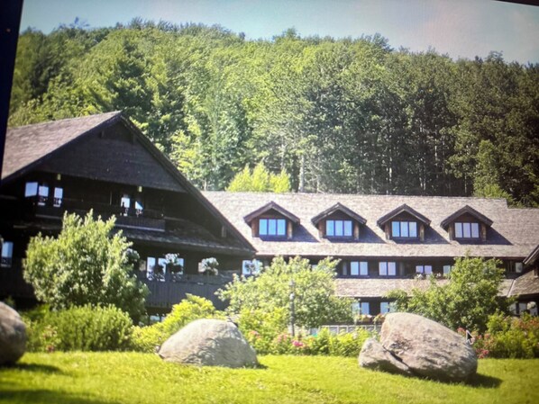 Un chalet doté d’un toit à forte pente, de nombreuses lucarnes et d’un grand jardin de rocaille.