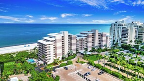 A high-rise hotel with multiple floors, a parking lot, and a view of the beach and ocean. - 7th-Floor Beachfront Marco Island Condo with Panoramic Ocean & Sunset Views (Marco Island)