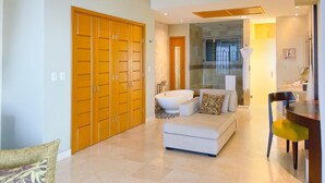 A modern living room with a sofa, ottoman, and a dining area with a table and chairs. - Luxury and quality located in the heart of Banderas Bay, Puerto Vallarta (Puerto Vallarta)
