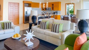 A modern living room with a sofa, coffee table, and chairs. There is a kitchen area with a refrigerator, microwave, and dining table. - Luxury and quality located in the heart of Banderas Bay, Puerto Vallarta (Puerto Vallarta)