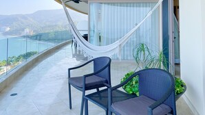 A balcony with a hammock, wicker furniture, and potted plants. - Luxury and quality located in the heart of Banderas Bay, Puerto Vallarta (Puerto Vallarta)