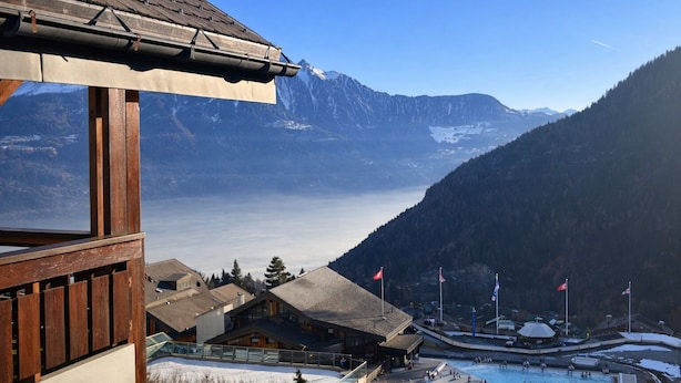 Eine Berghütte mit Blick auf einen See und Berge.