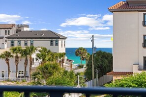 A coastal building with a view of the sea, surrounded by palm trees and a white fence. - Beach House · Private Beach · Private Pool & Backyard · Steps to Sand (Miramar Beach)