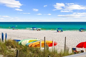 A beach with umbrellas and beach chairs, a lifeguard stand, and a clear view of the ocean. - Beach House · Private Beach · Private Pool & Backyard · Steps to Sand (Miramar Beach)