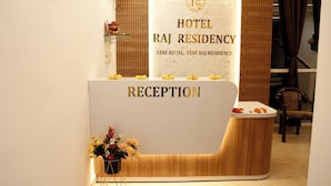 A reception desk at Hotel Raj Residency with a marble top and a wooden base. - Hotel Raj Residency (Bhatapara)