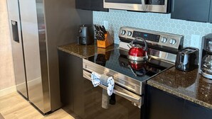 A modern kitchen with stainless steel appliances, a microwave, a kettle, and a toaster. - Magic Spring (Kissimmee)