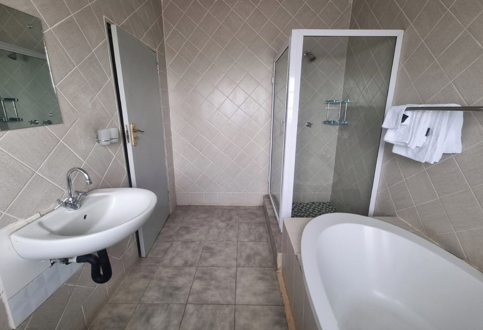 Une salle de bain équipée d’un lavabo, de toilettes, d’une douche et d’une baignoire.