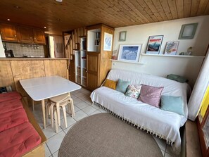 Ein gemütliches Blockhaus-Interieur mit einem Esstisch, einer Couch und einer roten Bank.