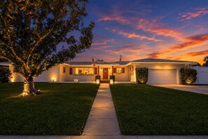 A two-story house with a front lawn, a driveway, and a garage. - Private Pool Oasis Near Anna Maria Island + Tiki Bar + Games + Sleeps 12 (Bradenton)