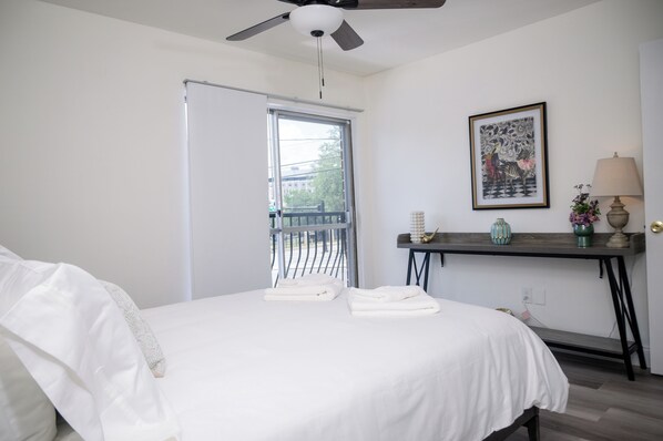 A bedroom with a bed, a desk, a ceiling fan, a window, and a framed picture on the wall. - Entire 1-Bed Condo Across From Shands Hospital & Close To University Of Florida (Gainesville)